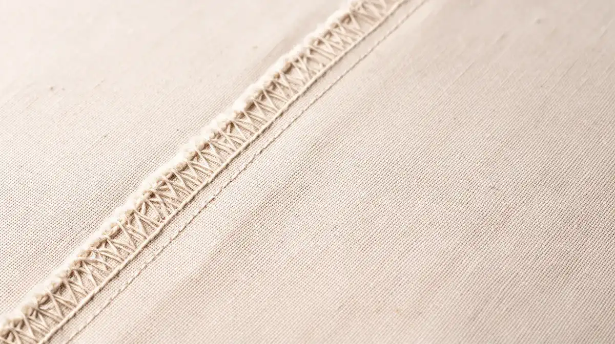 Gros plan sur la lisière d'un tissu montrant les fils de chaîne parallèles, le droit fil