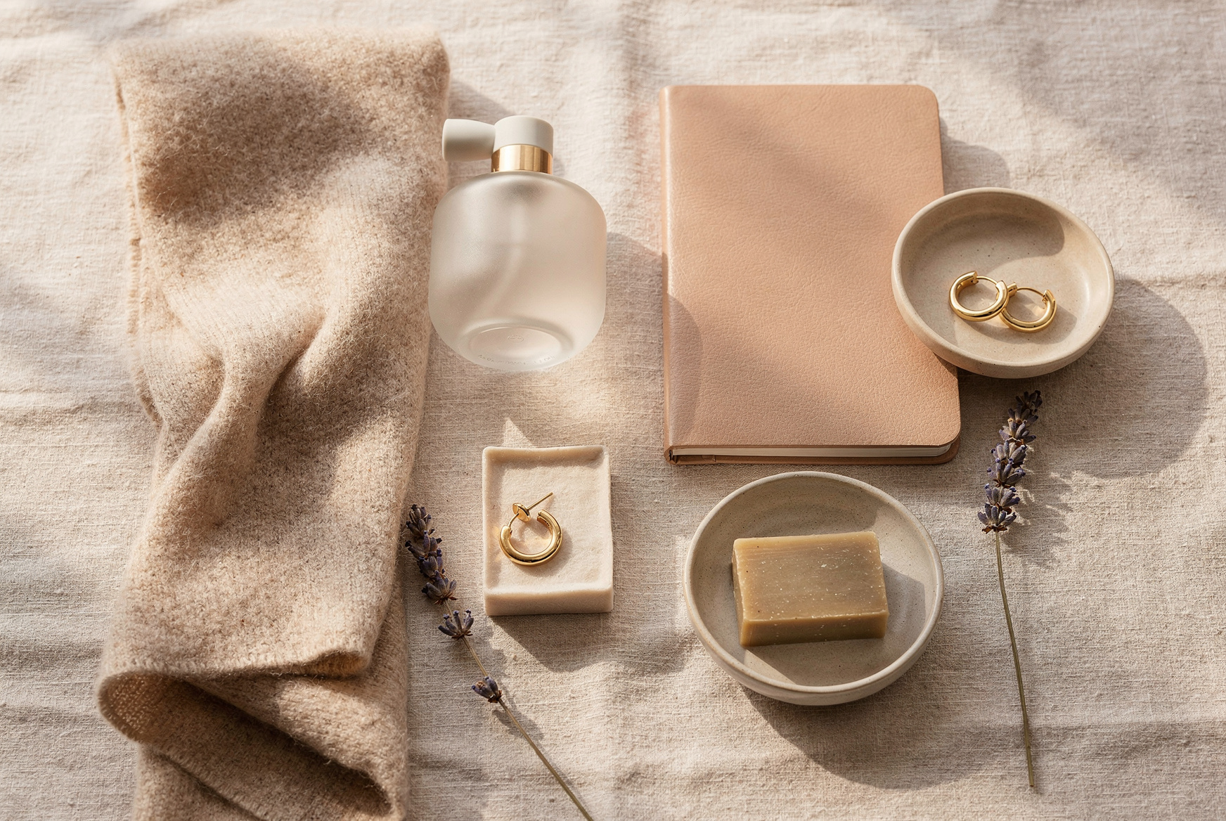 Idées de cadeaux pour femme : parfum, écharpe en laine, carnet, boucles d'oreilles dorées et savon artisanal